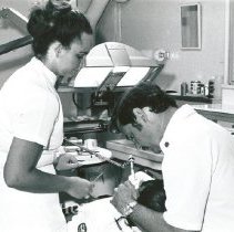 Dr William Elkins, Dentist, with Mary Beth Villanova assisting.